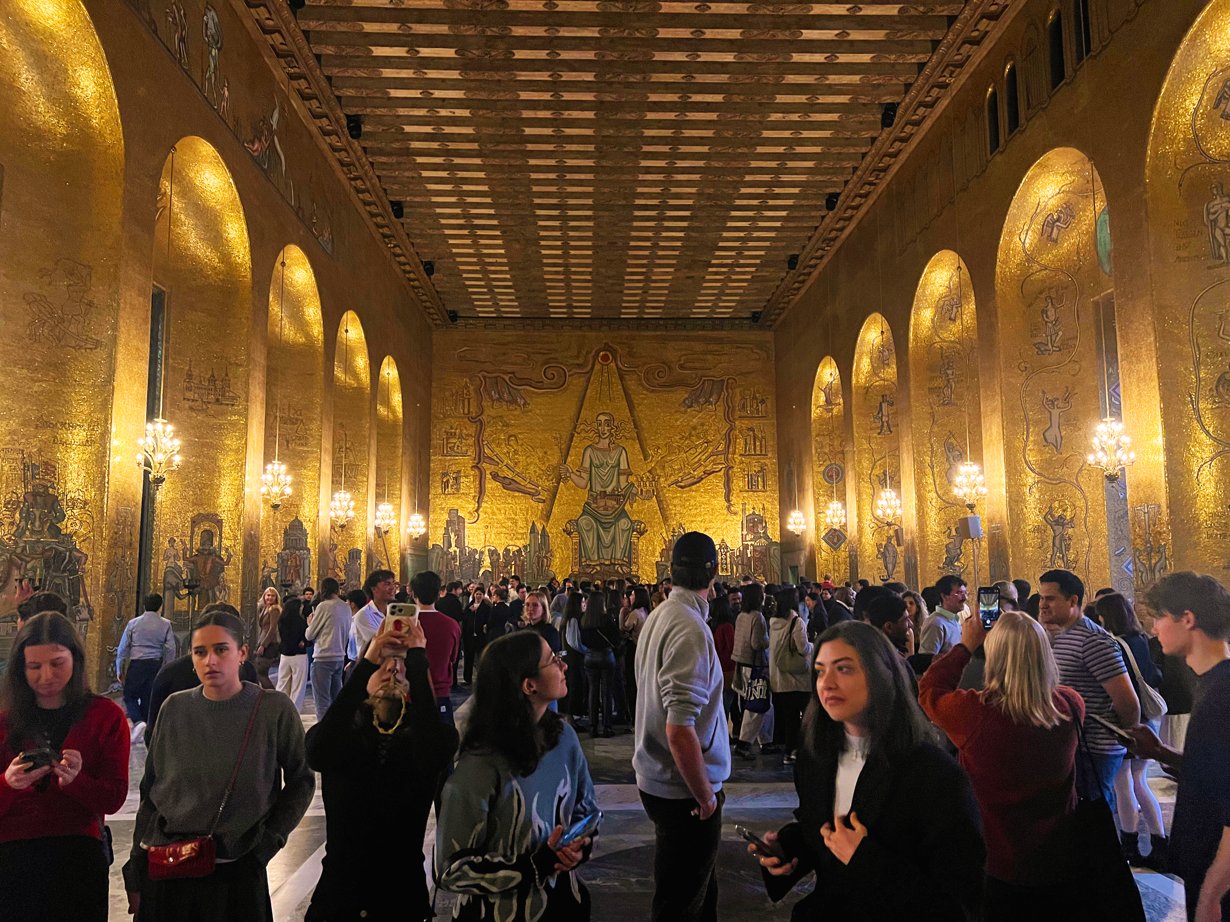 International students exploring the Golden Hall at Stockholm City Hall, surrounded by its famous golden mosaics.